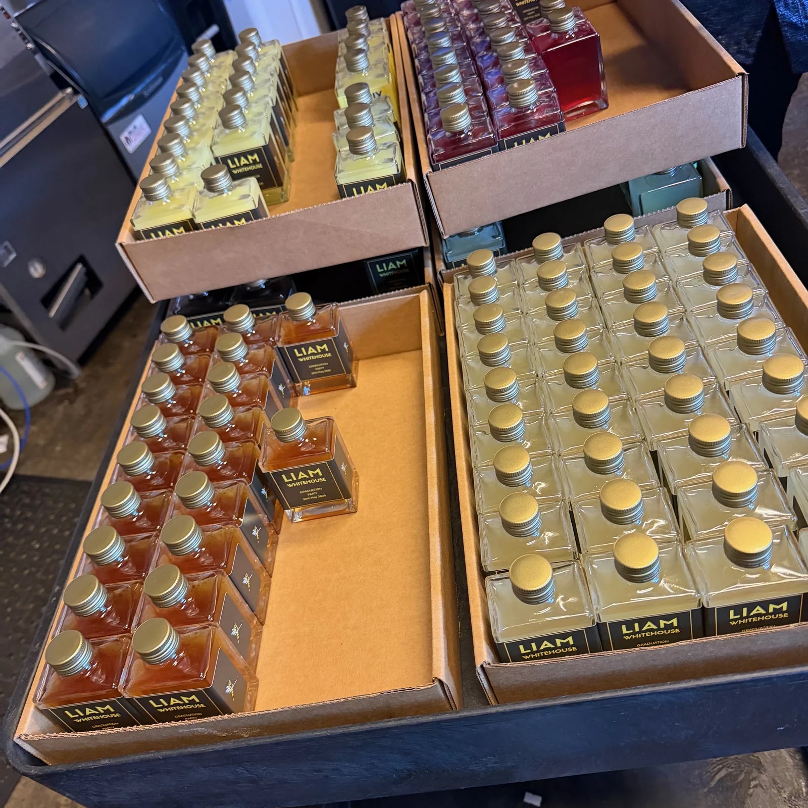 Trays of custom labeled 100mL Maux cocktails being packed for an event